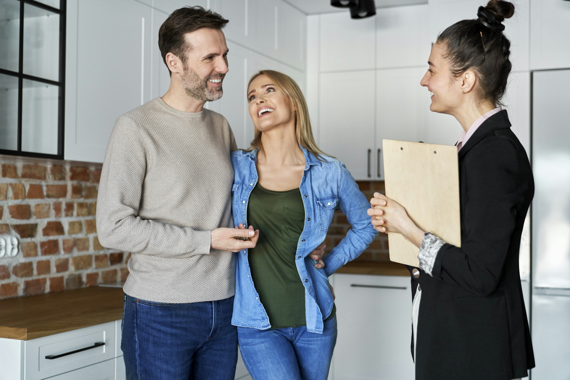 Happy couple talking to a real estate agent
